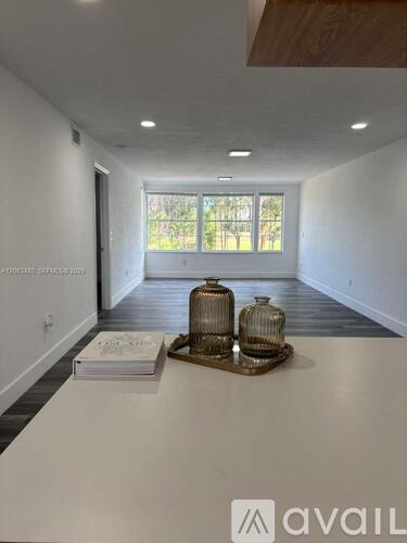 A room with a white table and two vases on it.