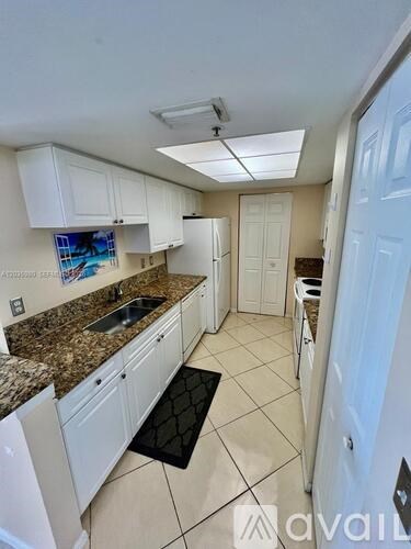 A kitchen with white cabinets and a granite countertop.