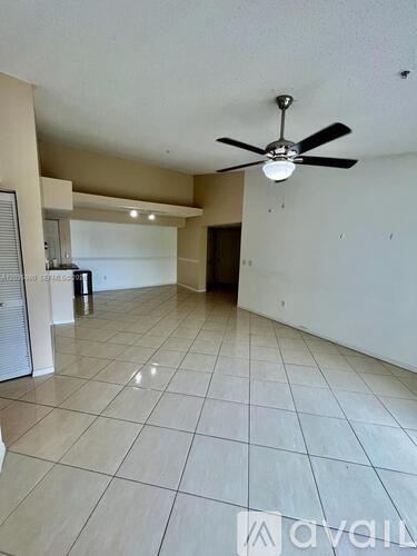 A spacious room with a ceiling fan and tiled flooring.