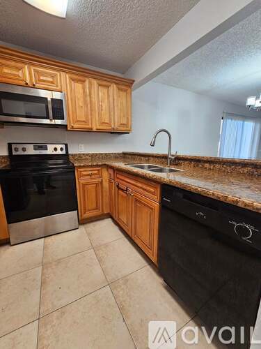 A kitchen with wooden cabinets and black appliances.