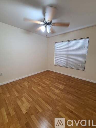 A room with wooden flooring and a ceiling fan.