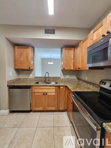 A kitchen with wooden cabinets and granite countertops.