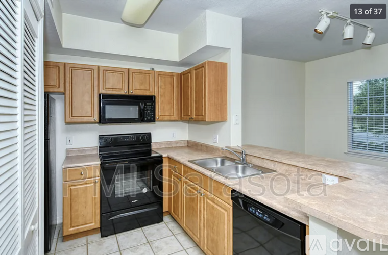 A kitchen with wooden cabinets and black appliances.