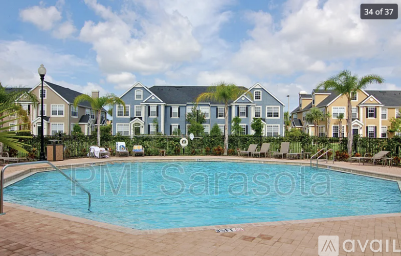 A pool in front of apartment buildings with the text "PMI Sarasota" on the side.