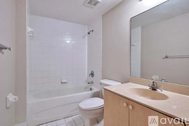 A bathroom with a white toilet, a white bathtub, and a sink.