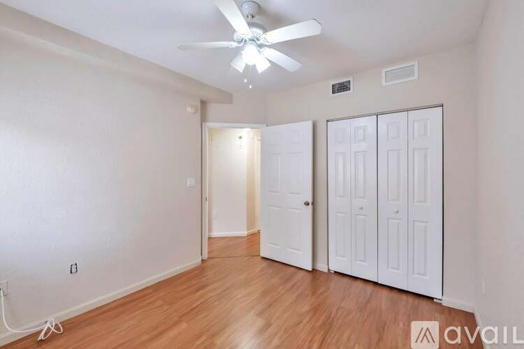 A room with a ceiling fan and wooden flooring.