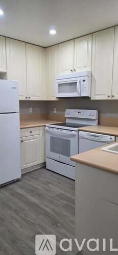 A kitchen with white appliances and cabinets.