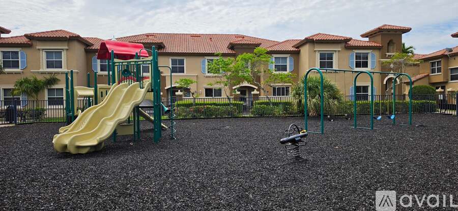 A playground with a yellow slide and a green swing set.