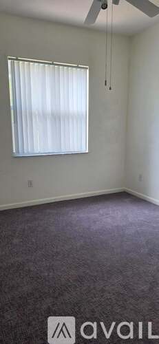 A room with a window and a ceiling fan.