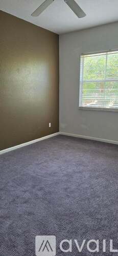 A room with a window and a ceiling fan.