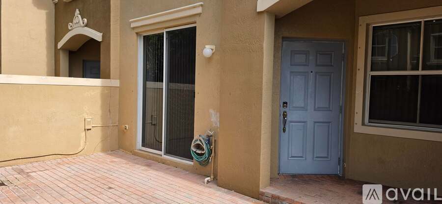 A blue door is on the right side of a tan building.