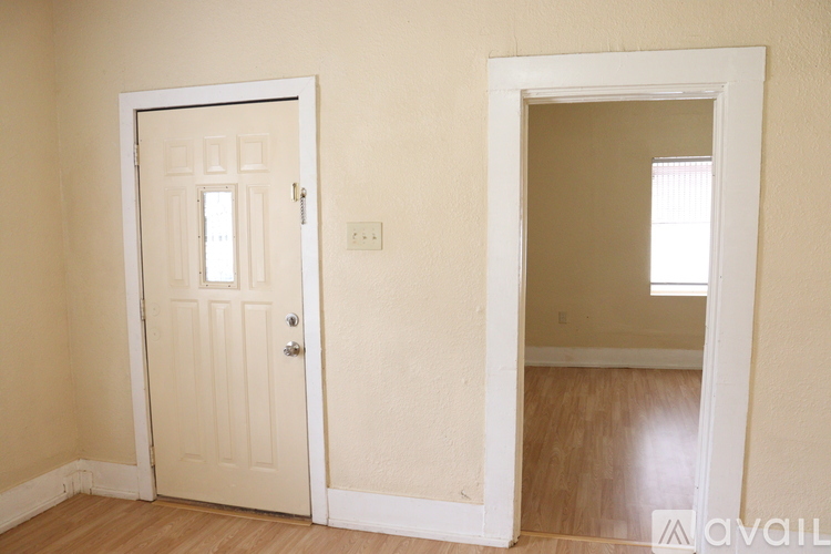 A room with a white door and a white frame window.