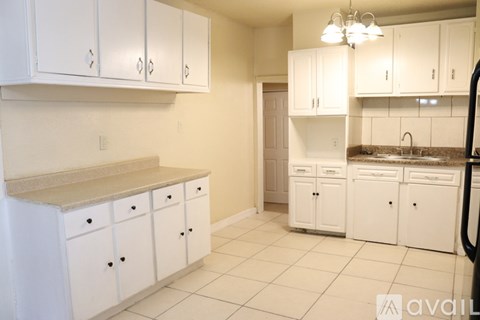A kitchen with white cabinets and a granite countertop.