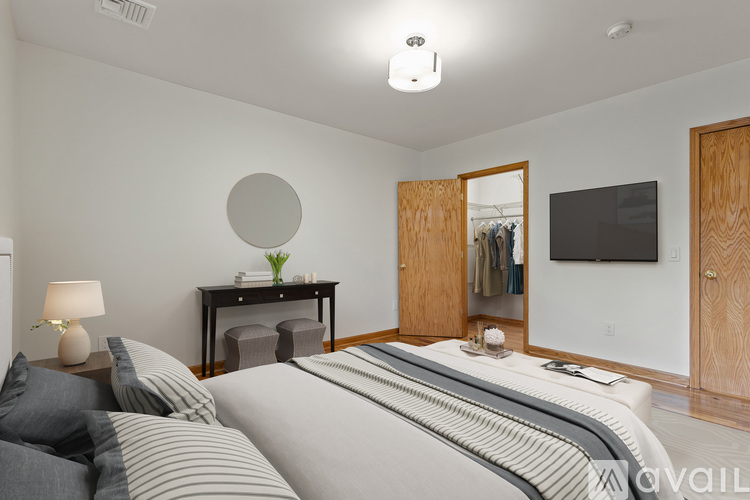 A bedroom with a large bed and a flat screen TV mounted on the wall.