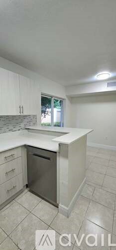 A kitchen with white cabinets and a marble countertop.