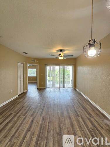 A room with wooden flooring and a ceiling fan.
