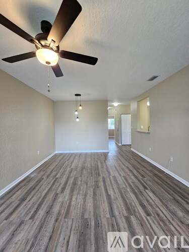 A room with wooden flooring and a ceiling fan.