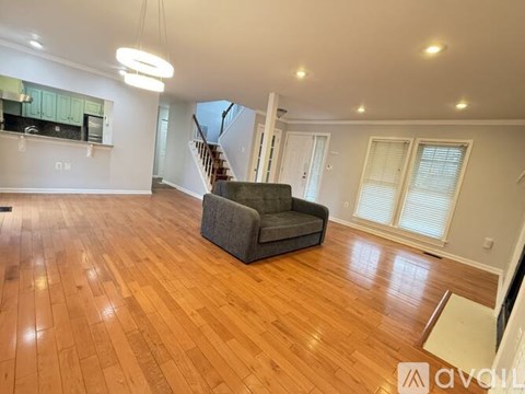 A living room with a grey sofa and wooden flooring.