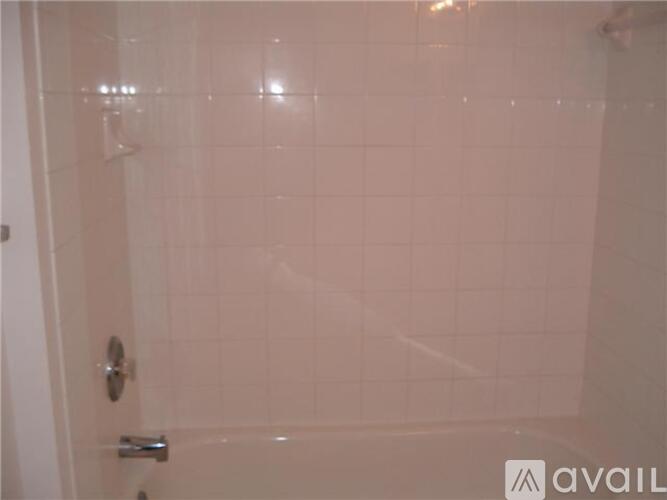 A white tiled shower stall with a door.