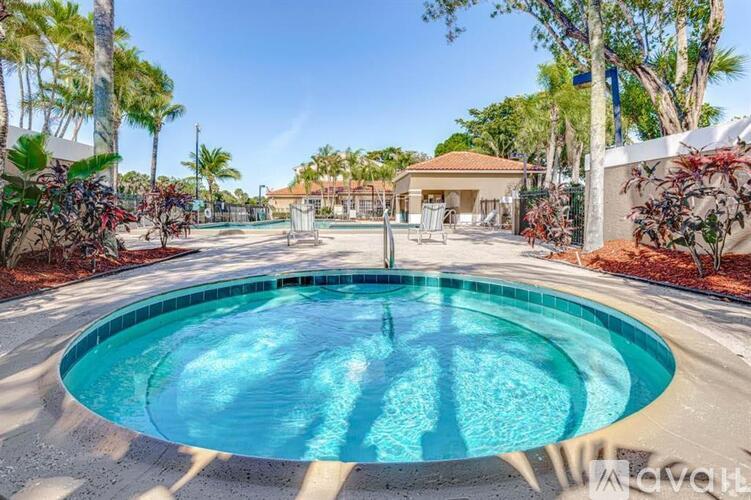 A pool surrounded by trees and a building in the background.