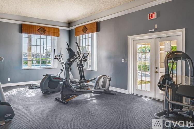 A gym with exercise equipment and a door marked exit.