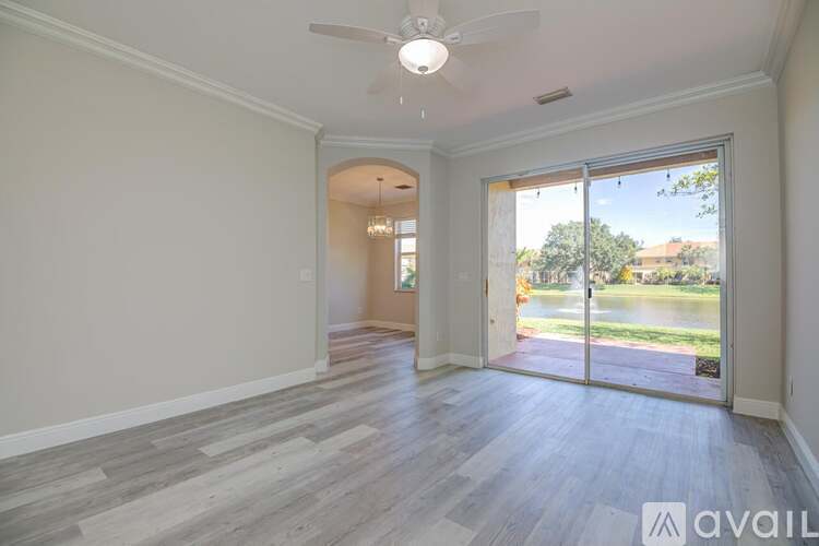 A spacious room with a sliding glass door leading to a backyard.