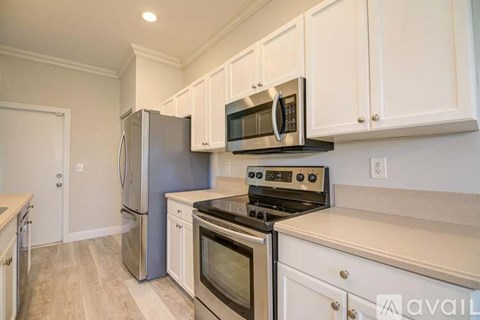 A kitchen with white cabinets and stainless steel appliances.