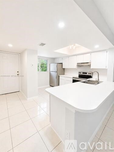 A white kitchen with a large island in the middle.