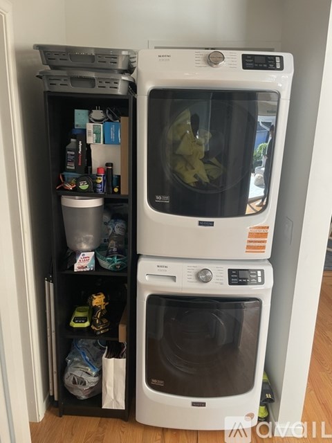 A white dishwasher and microwave are stacked on top of each other in a small kitchen.