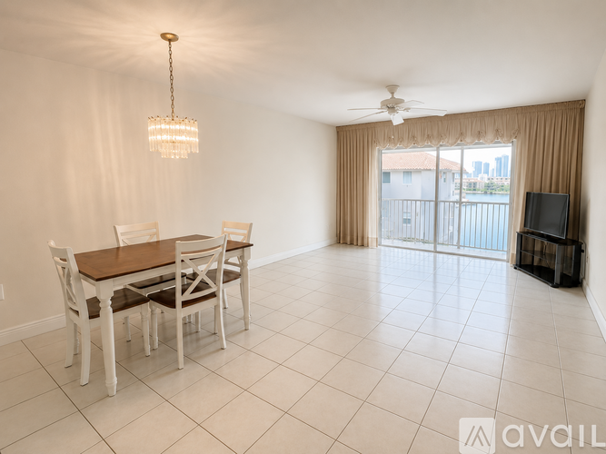 A dining room with a table and chairs and a television.