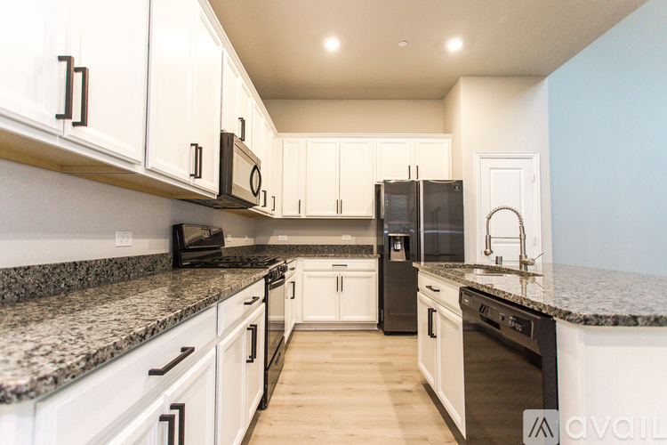 A kitchen with white cabinets and granite countertops.