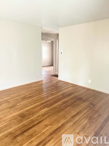 A room with wooden flooring and white walls.