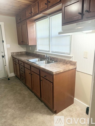 A kitchen with brown cabinets and a granite countertop.