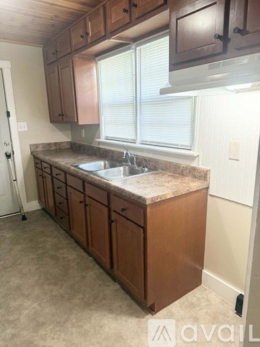 A kitchen with brown cabinets and a granite countertop.