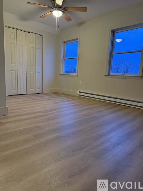 A room with wooden flooring and a ceiling fan.
