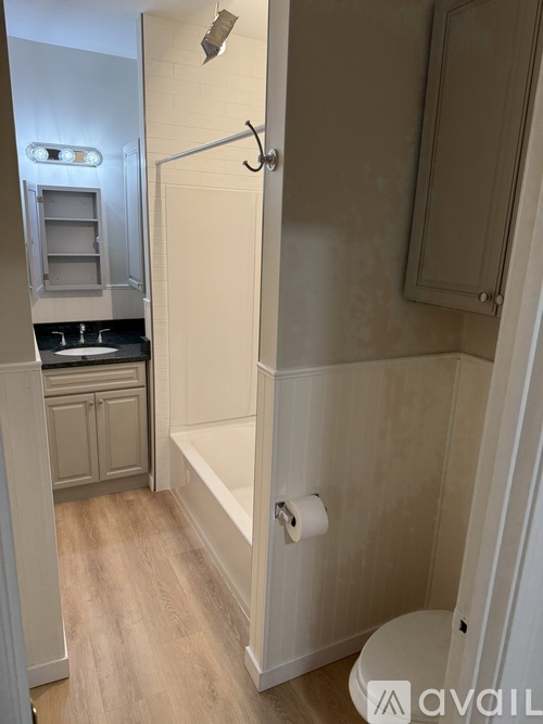A bathroom with a toilet, sink, and a shower stall.
