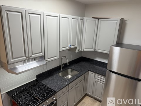 A kitchen with a stove top oven and a refrigerator.