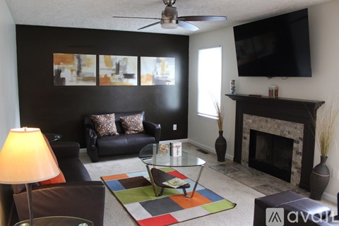 A living room with a fireplace and a television mounted on the wall.