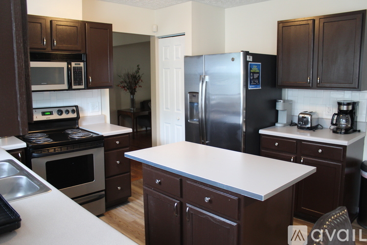 A kitchen with brown cabinets and a white counter.