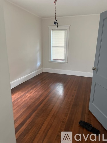 A room with wooden flooring and a window.