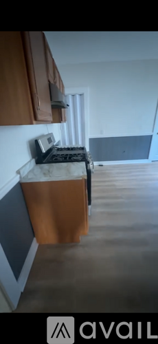 A kitchen with brown cabinets and a white wall.