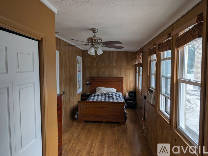 A bedroom with a bed, dresser, and window.