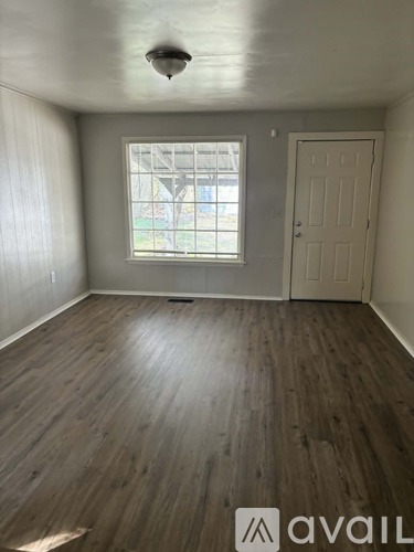 A room with wooden flooring and a window.