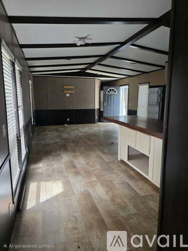 A spacious room with wooden flooring and a ceiling fan.
