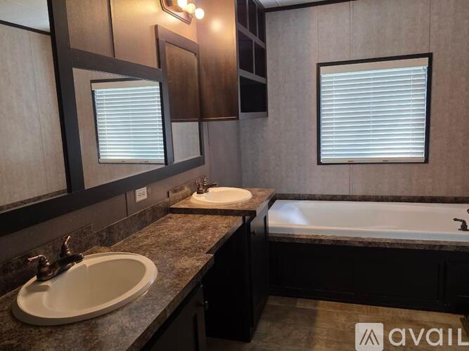 A bathroom with a sink, mirror, and bathtub.