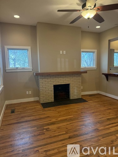 A room with a fireplace and a ceiling fan.