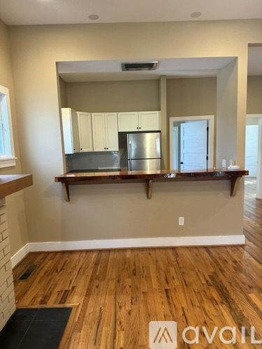A kitchen with wooden floors and a large mirror above the counter.