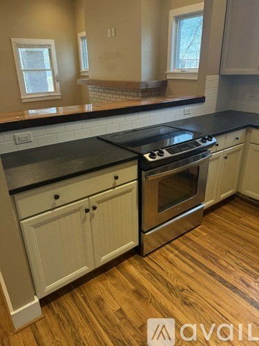 A kitchen with a black countertop and a stove top oven.
