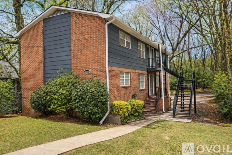 A house with a brick exterior and a black roof is for sale.