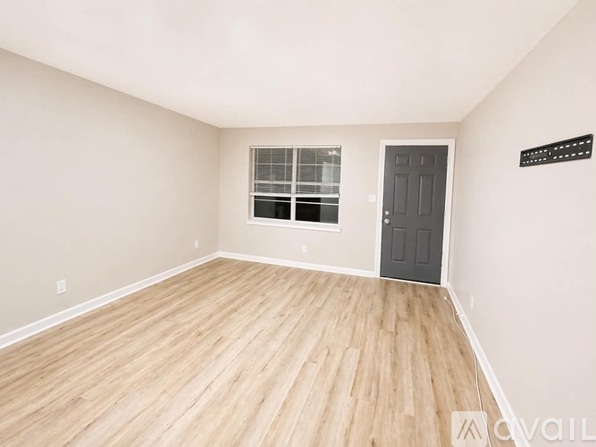 A room with a wooden floor and a black door.